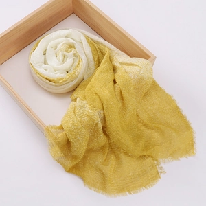 Detailed view of yellow and white tie-dye scarf with crinkled texture and fringe trim