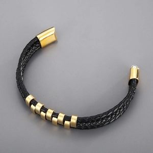 Macro view of men's multi-layer black woven leather bracelet with gold metal magnetic clasp