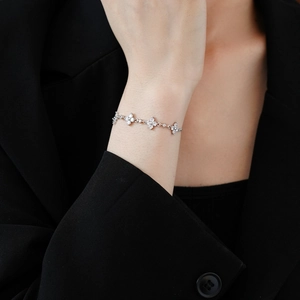 Nahaufnahme eines Zirkon-Schneeflockenarmbands am Handgelenk mit schwarzem Anzug