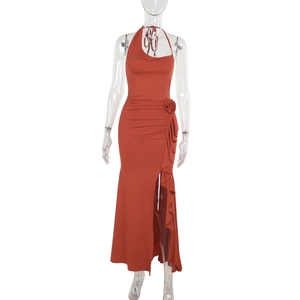 Detalle del vestido naranja con cuello halter, abertura lateral con volantes y flor 3D