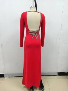 Detail view of red backless evening gown featuring silver leaf embroidery on lower back