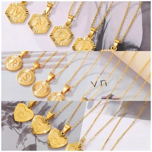 Detailed close-up of golden alphabet pendants in heart, circle, and hexagon shapes