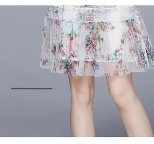 Detail des Blumen-Chiffonkleid-Saums mit weißem Spitzenbesatz und elegantem Stofffall