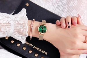 Detail of rose gold mesh watch with green sunray dial and matching diamond bracelet