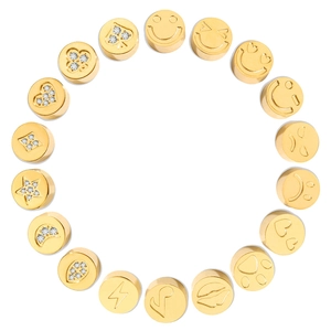 Vista macro di perline placcate in oro 14k con motivi a cuore, stella e smiley con zirconi