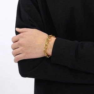 Close-up of polished gold-plated stainless steel chain bracelet on a male model's wrist