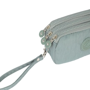 Pale green nylon crossbody phone bag with three zipper pockets and a matching wrist strap