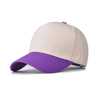 Detail of two-tone cotton baseball cap showing purple curved brim and beige crown stitching