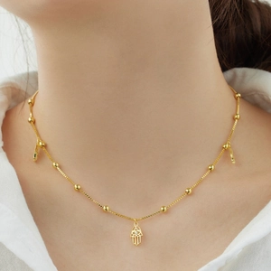 Détail d'un collier main de Fatma dorée avec oxydes de zirconium sur un mannequin