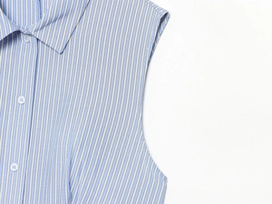 Dettaglio di camicia senza maniche a righe azzurre con colletto classico e bottoni frontali