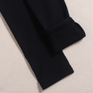 Detail view of the fine stitching and high-quality black knit fabric of the U-neck top