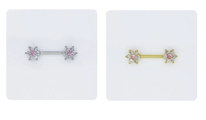 Detailed macro of gold and silver flower nipple rings with pink zircon center stones