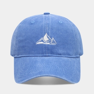 Macro detail of the white mountain peak embroidery on the navy blue washed cotton cap