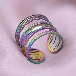 Macro detail of multi-layer rainbow stainless steel open ring on purple silk
