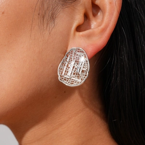 Macro shot of silver hollow geometric earrings with inlaid rectangular zircons on model
