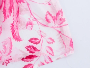 Gros plan d'un imprimé floral rose sur un tissu en mousseline semi-transparent
