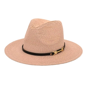 Detail of apricot straw fedora featuring a fine woven texture and black decorative band