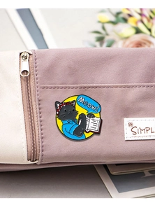 Close-up of cat enamel pin with red headband on canvas pouch showing muscle pose