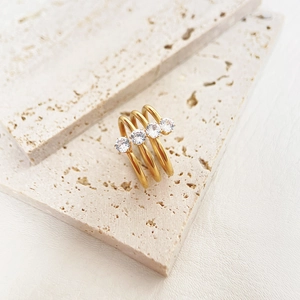 Detailed close-up of triple-layered 18k gold plated ring with sparkling zircon stones