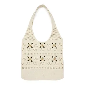 Detailed close-up of ivory crochet tote bag featuring green floral embroidery and hollow knit