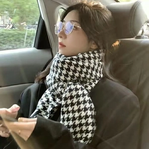 Close-up of black and white houndstooth scarf worn by a woman in a car setting