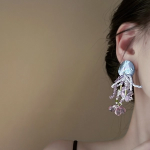 Fairy style purple crystal bead drop earrings with shell accents shown on a model
