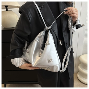 Dettaglio borsa tote in pelle PU argento con decorazioni a farfalla e forma asimmetrica