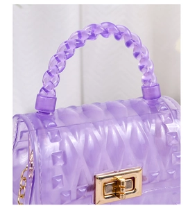 Detail of purple transparent jelly bag with embossed diamond pattern and gold twist lock