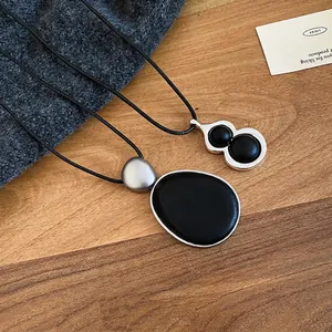 Collier minimaliste avec pendentif calebasse ovale en bois noir et cadre en argent
