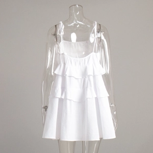 Detail of white tiered ruffle sundress featuring spaghetti straps and bow tie accents