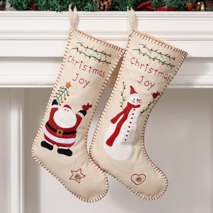 Ethnic style Christmas stockings with Santa and Snowman embroidery on white fireplace