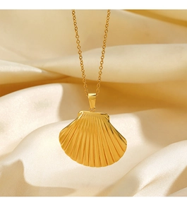 Detail of a golden seashell pendant necklace on elegant beige silk fabric background