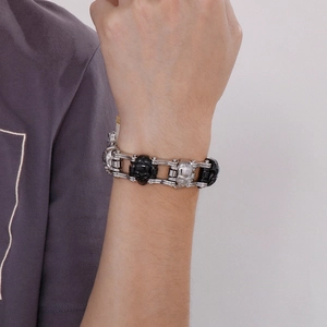 Close-up of hip hop skull bracelet with silver and black metal chain on male wrist