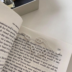 Macro detail of S925 sterling silver pig nose chain bracelet on an open book page
