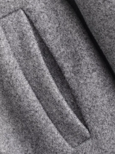 Detail of grey woolen jacket showing premium pocket stitching and fabric texture
