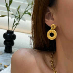 Macro shot of gold double-hoop earrings featuring intricate radial pleated texture details