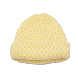Detail of light yellow chunky knit texture on cozy winter beanie with rolled cuff