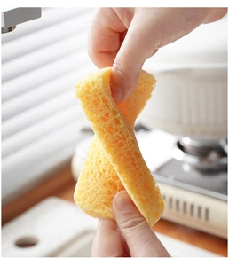 Close-up showing the flexibility of yellow wood pulp sponge being twisted by hands