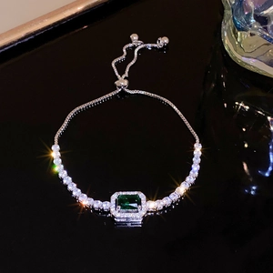Gros plan d'un bracelet avec pierre verte taille émeraude et fermoir réglable sur miroir