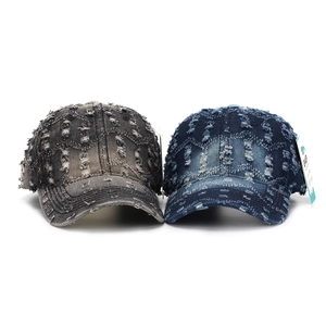 Side view of two distressed washed denim baseball caps with vintage ripped details