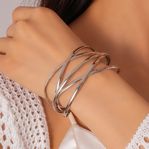Silver multi-layer crossover metal bangle shown on wrist for geometric minimalist style