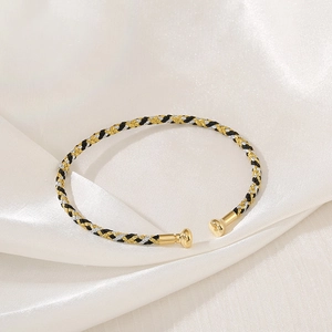 Detailed view of the three-color braided metallic bracelet with gold-tone round end caps