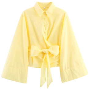Détail du chemisier jaune en popeline avec boutons dorés, col à revers et nœud