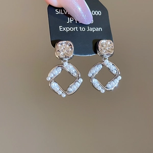 Detailed close-up of square pearl earrings featuring s925 silver needles and gold plating