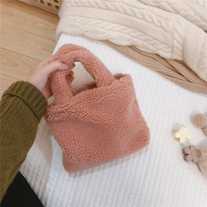 Gros plan d'un mini sac rose en polaire bouclée avec texture douce et anse ronde