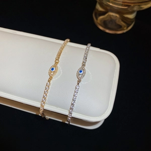 Close-up of gold and silver evil eye bracelets with sparkling zircon in a white jewelry box