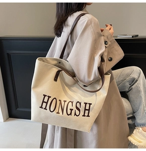 Close-up of high-capacity canvas tote bag with HONGSH print and brown leather straps