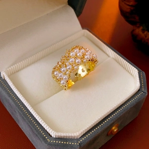 Primo piano di un anello dorato con perle in una lussuosa scatola regalo