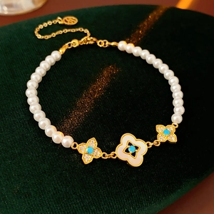 Dettaglio del bracciale di perle placcato oro 18k con quadrifogli in madreperla bianca
