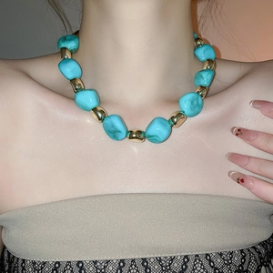Detail of chunky turquoise and gold acrylic beads on a vintage statement necklace